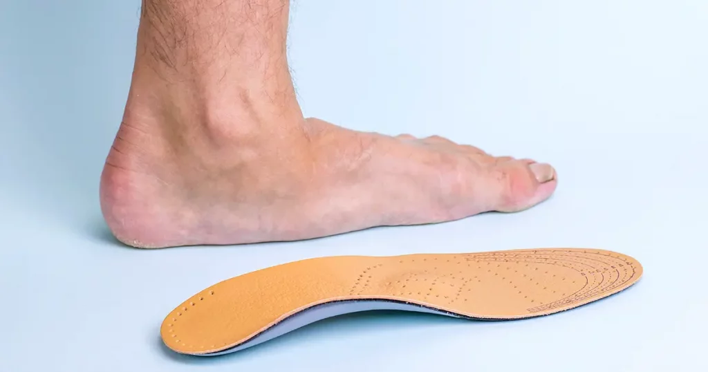 The left leg of an adult male with signs of foot disease next to the orthopedic insole