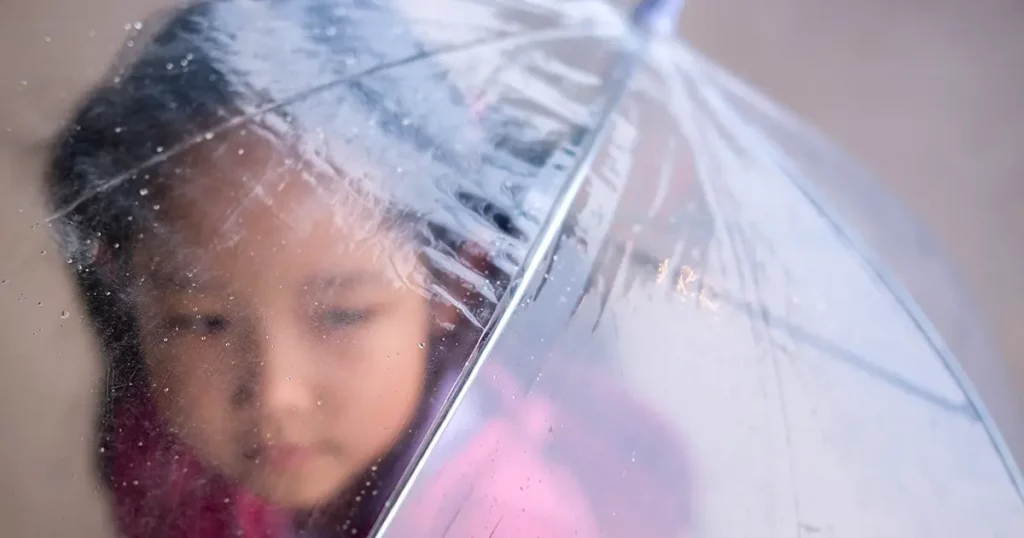Blur , Young girl holding umbrella under the rain.
