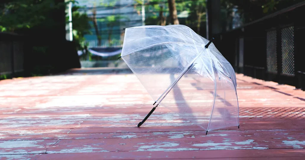 transparent umbrella on the wooden floor blur background