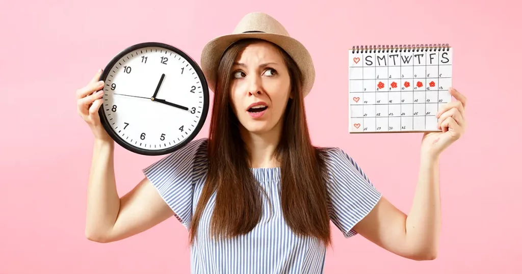 woman in blue dress holding round clock, female periods calenda