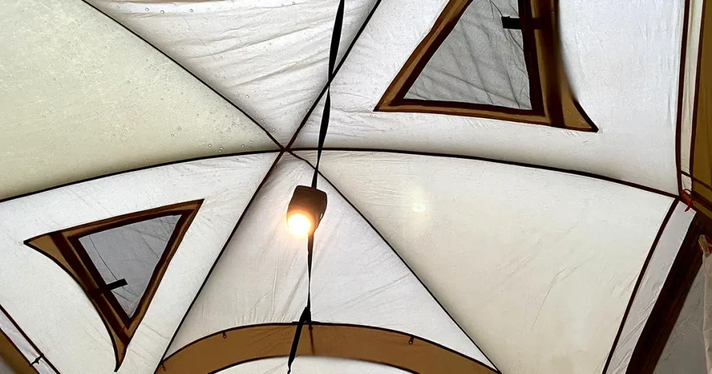 Lights are mounted on the ceiling of a large tent