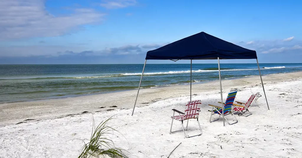 Portable Blue Canvass Shelter with Chairs Set up on the Beach