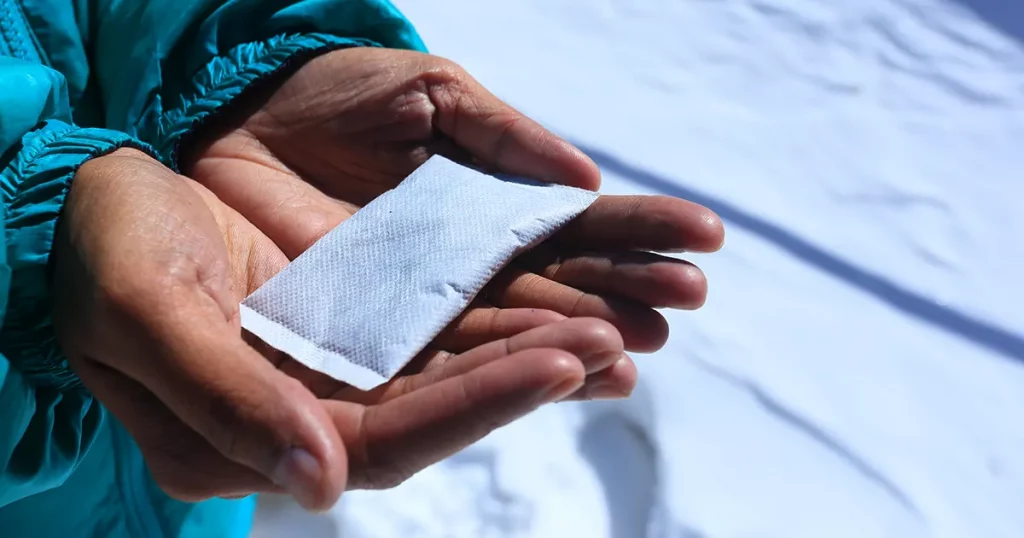 Hand warmers or Hot bag holds on hand asian women tourist for winter season , snow background