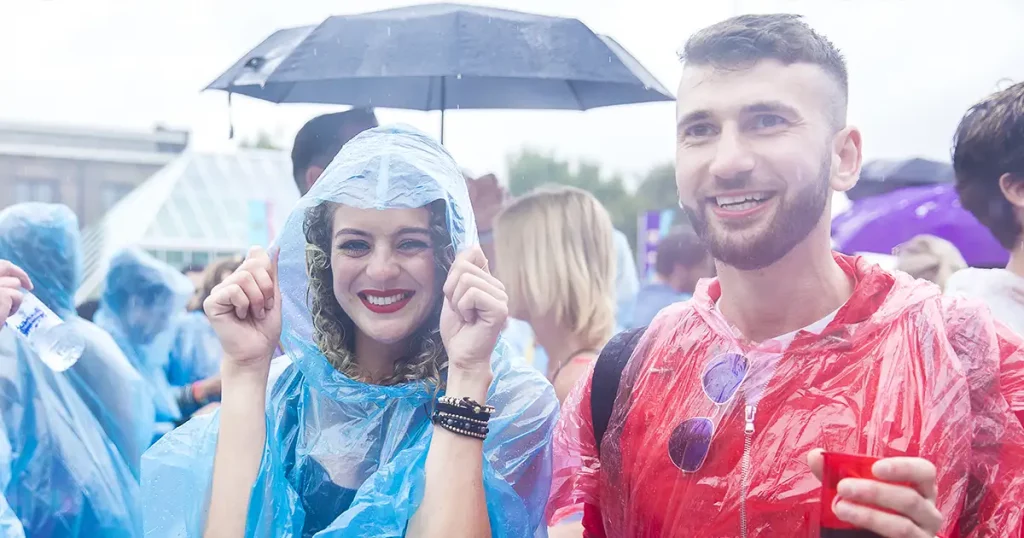 people dancing under the rain with their rain ponchos at Festival