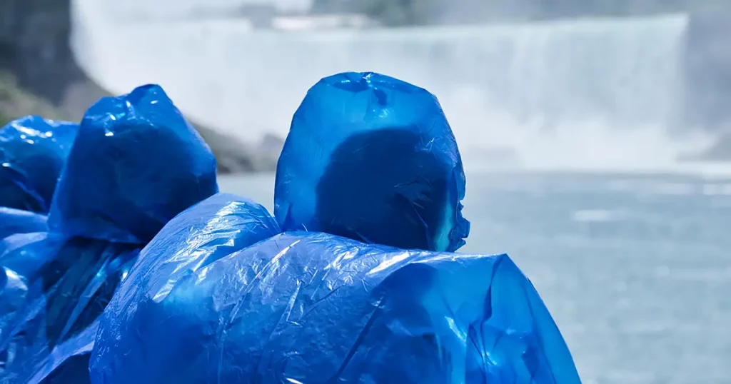 Tourists in rain ponchos watch the massive Niagara Falls