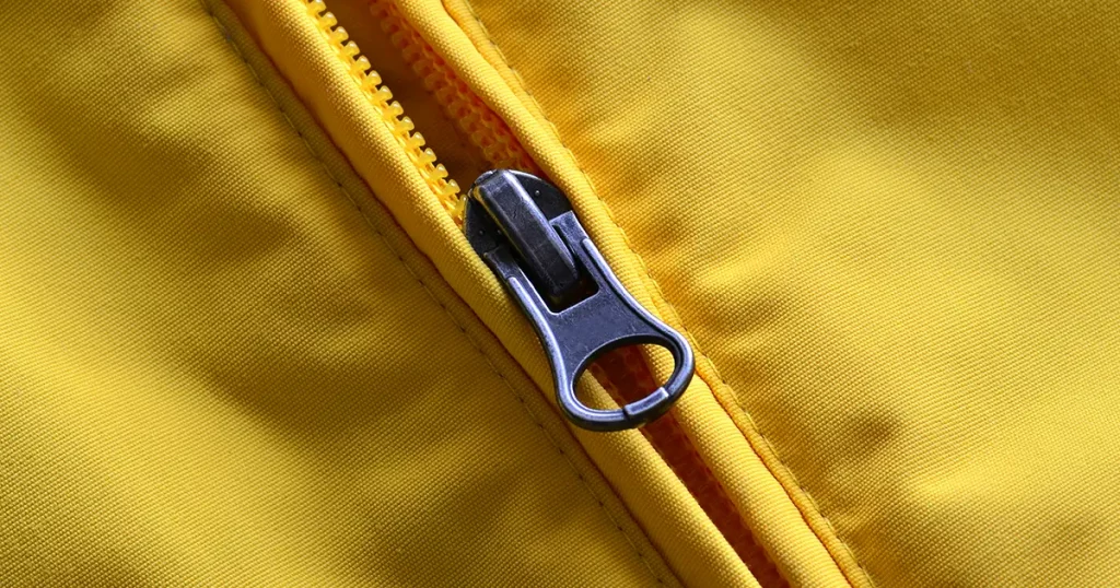 Closeup of zipper on Yellow coat with texture