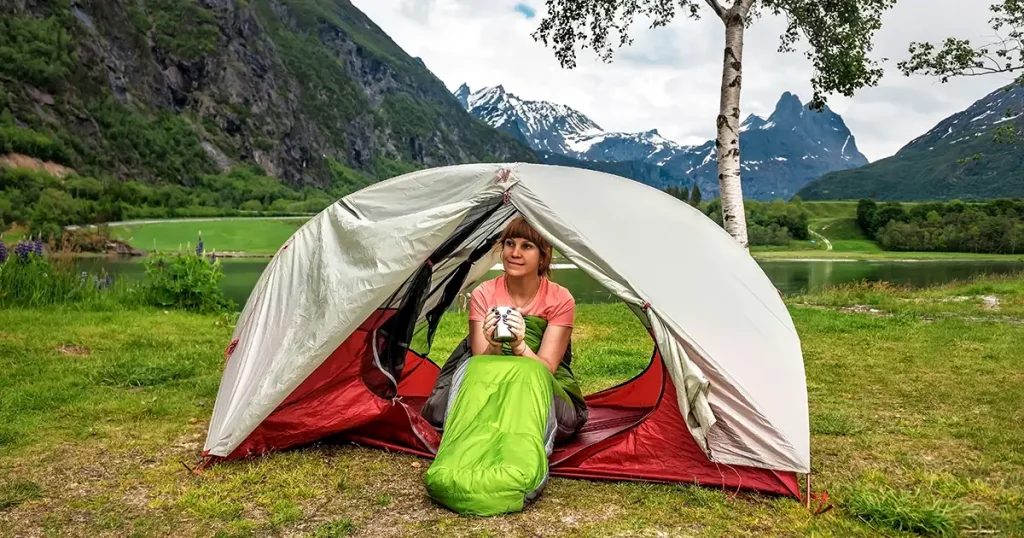 Tourist woman resting in the tent in Norway mountains