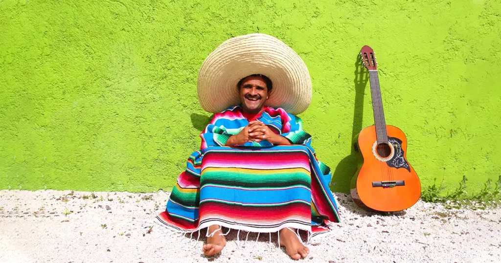 Mexican typical lazy topic man guitar poncho sit in green wall