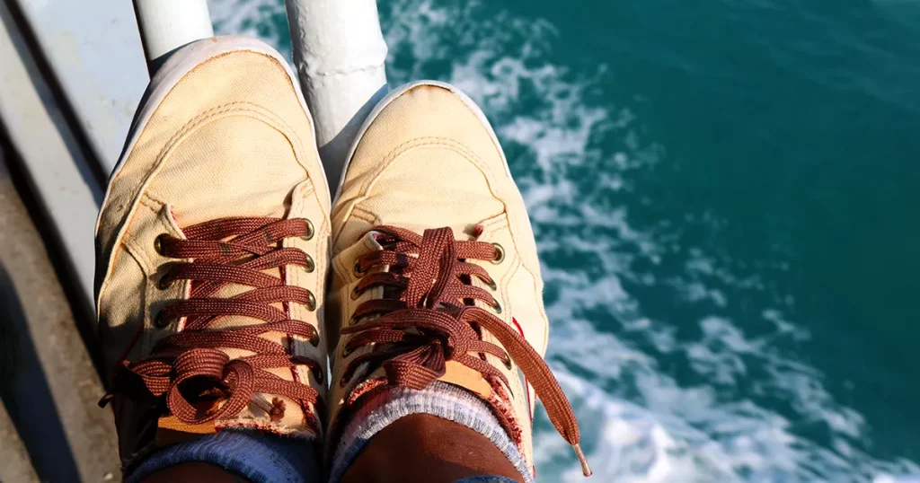 Feet and shoes on the boat.