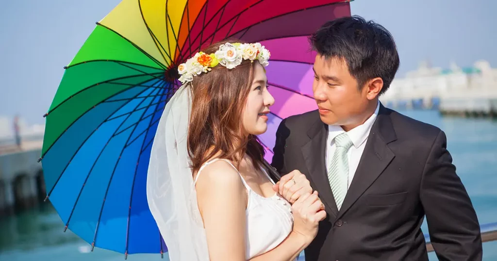 Beautiful asian couple on the beach in wedding dress