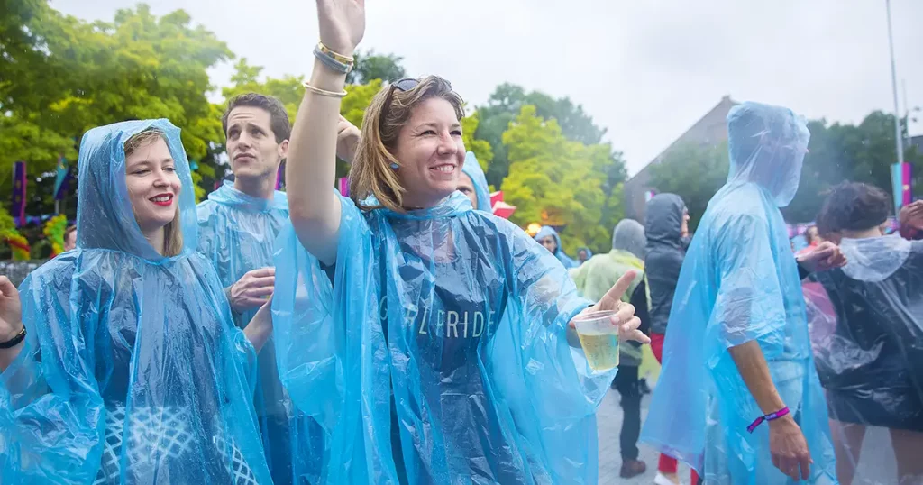 eople dancing under the rain with their rain ponchos