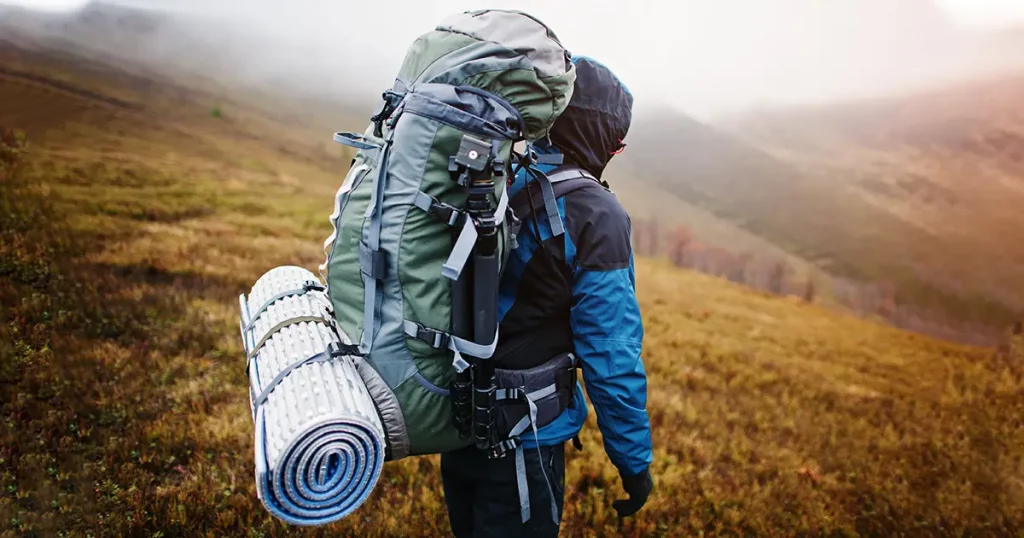 Close up view of back tourist backpack mats and tripod