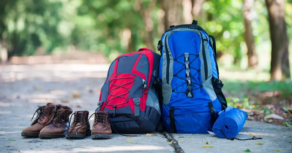 Backpack and shoes backpackers rest on the road while go hiking.