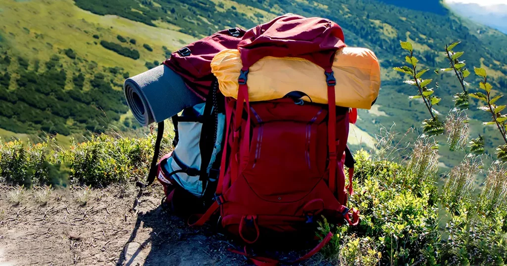 Backpack, sleeping mat in the mountains. Tourist equipment. Mountain landscape. Hiking in the mountains.