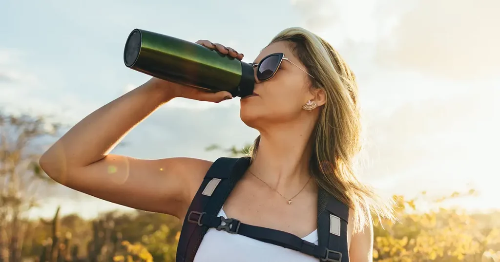 Woman taking a break to drink from water bottle while hiking at Brazilian Caatinga