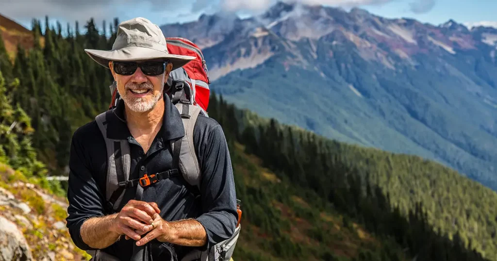 hiker-poses-front-mountain-peaks-range