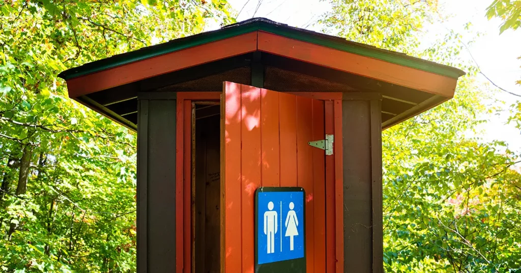 Gorgeous red and brown public toilet in the middle of the woods, Gatineau Park ,Quebec, Canada.