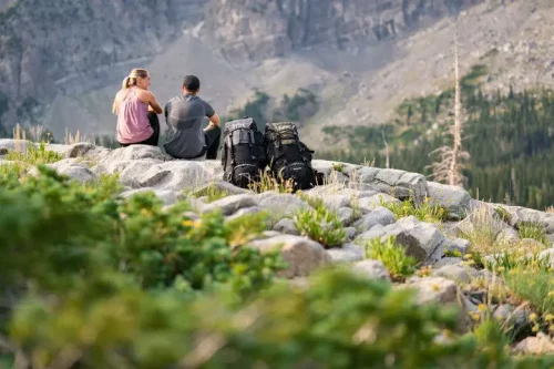 Lifestyle couple sitting on mountains with Teton Sports Explorer 4000 Backpacks